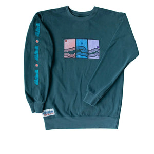Green long-sleeve shirt with graphic design on a wooden surface